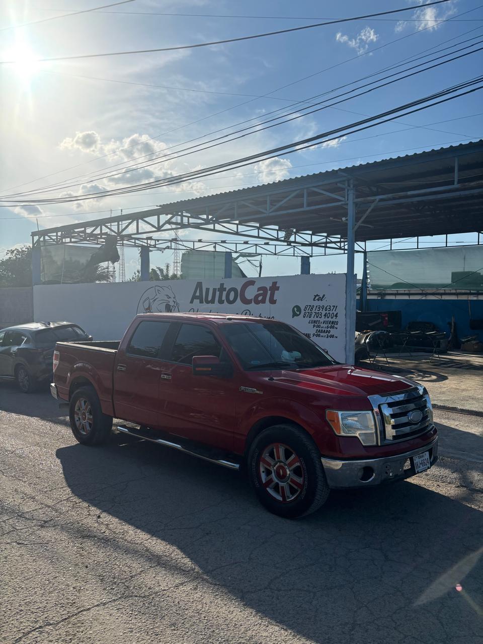 Pickup roja estacionada frente al taller AutoCat