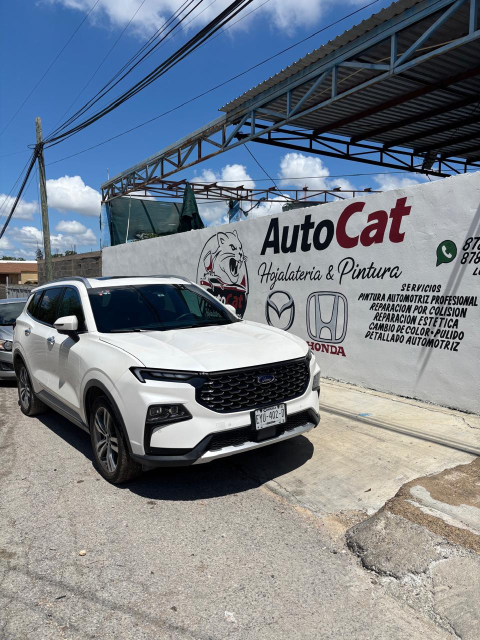 SUV Ford blanco frente al mural AutoCat